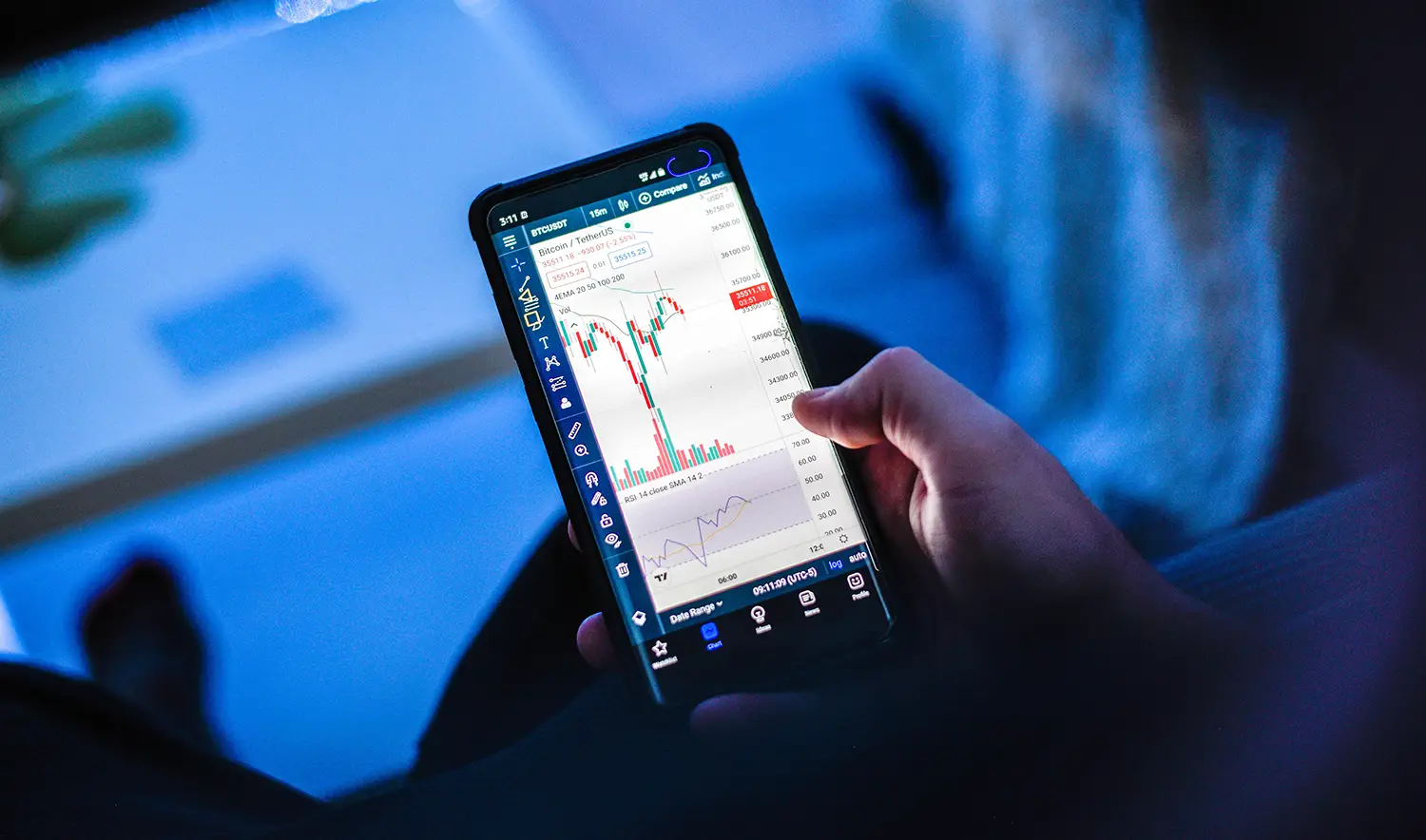 A photo of a person trading crypto on their phone.
